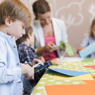 kids-teacher-cutting-paper-together